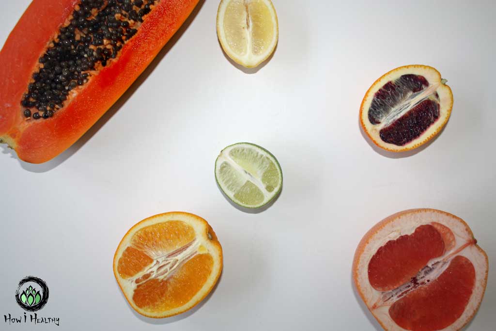 Citrus fruits cut in half on a white table.