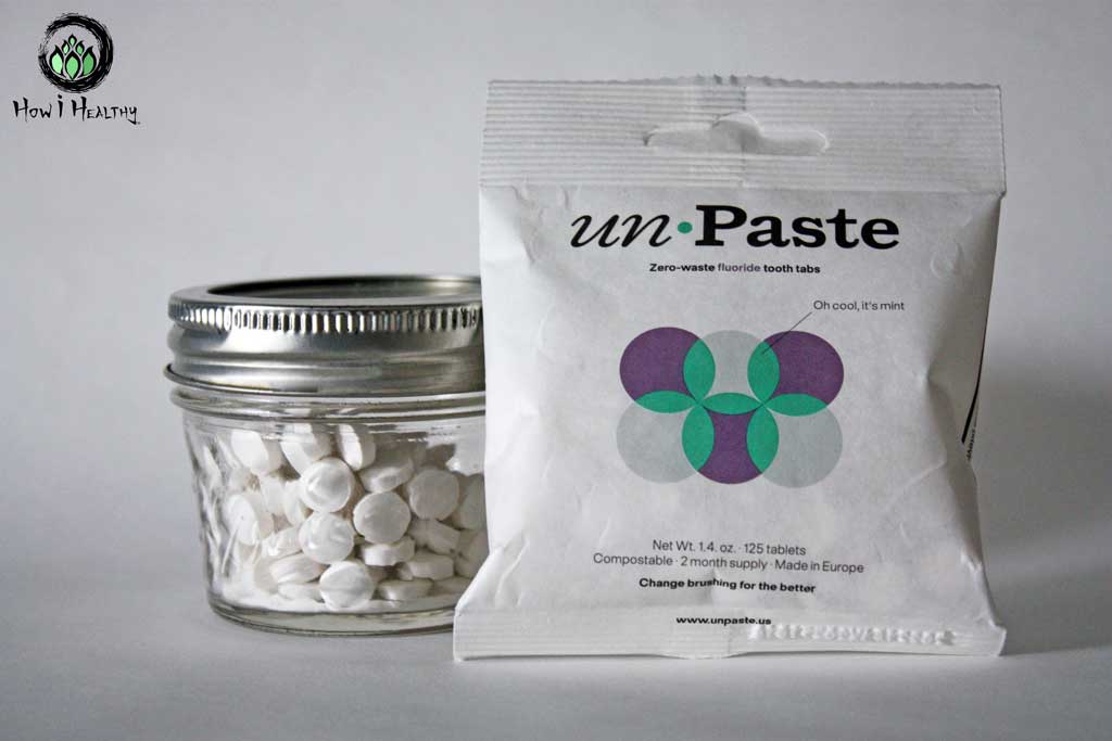 Zero waste teeth tabs beside glass jar filled with tooth tablets.