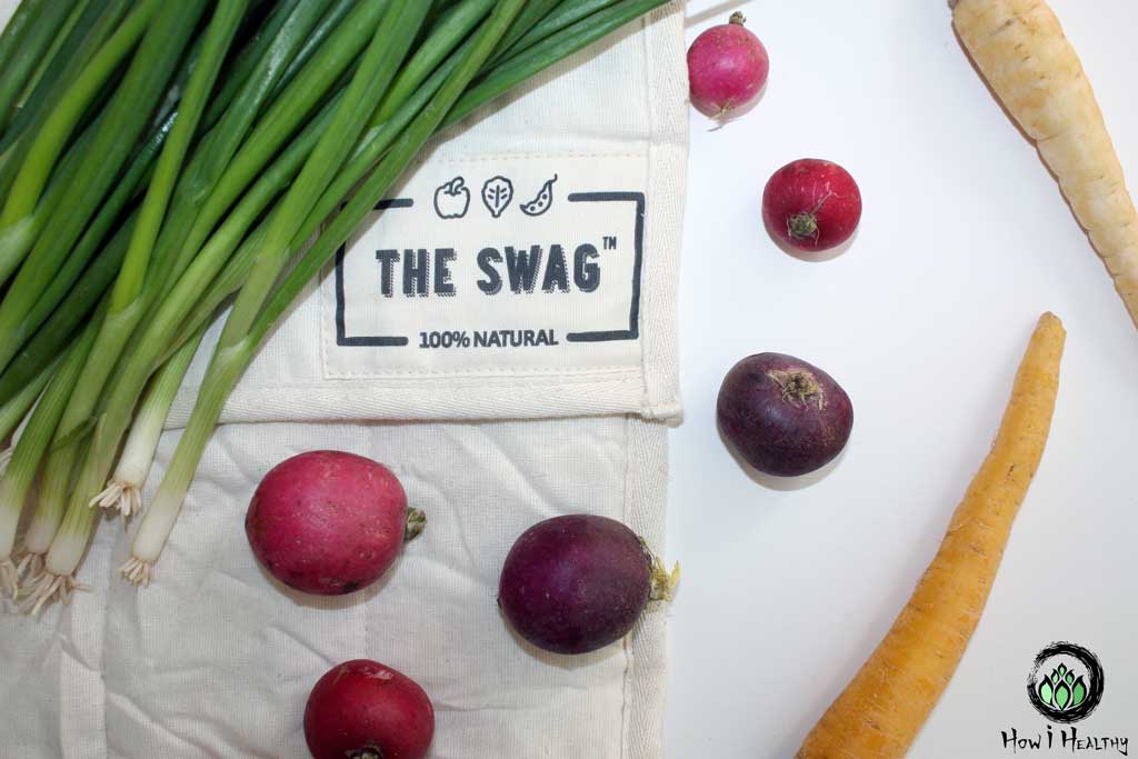 The Swag Bag cotton produce bag with root vegetables and green onions.