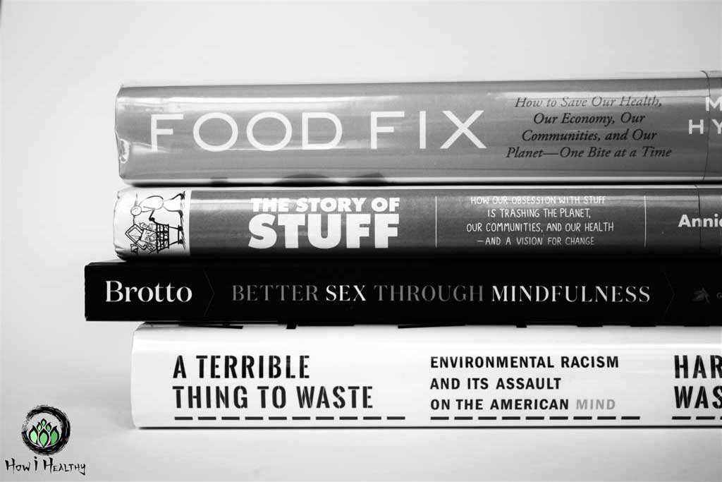 Stack of four books on white table.