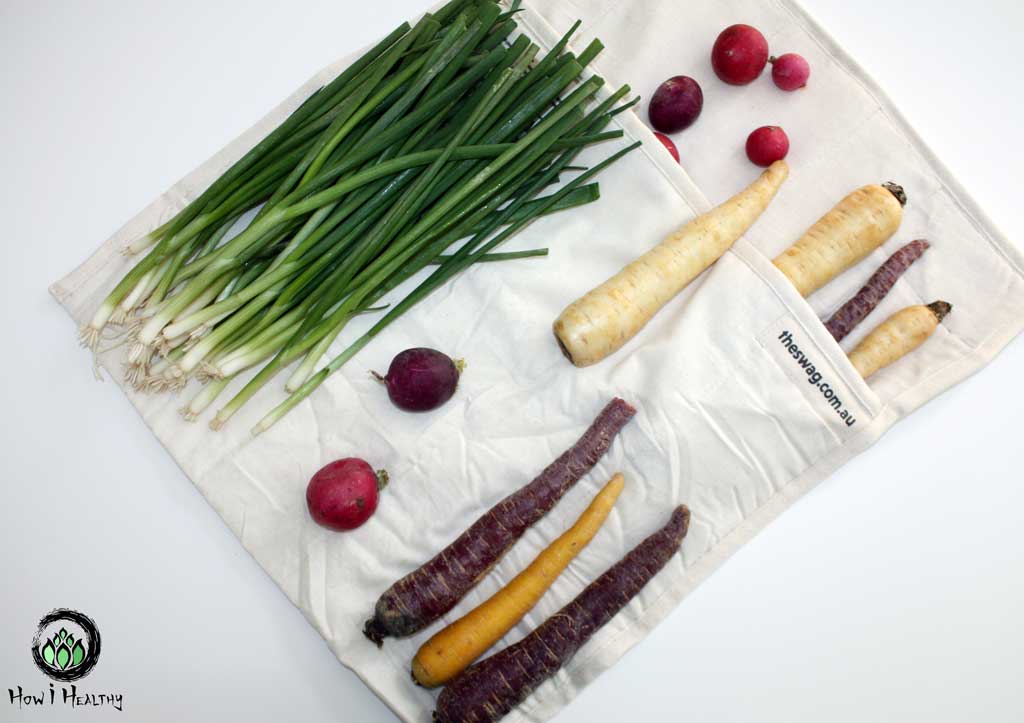 The Swag Bag cotton produce bag with root vegetables and green onions.