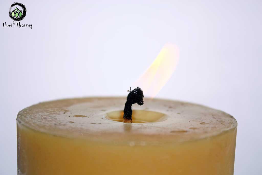 Close up of beeswax candle wick with flame.