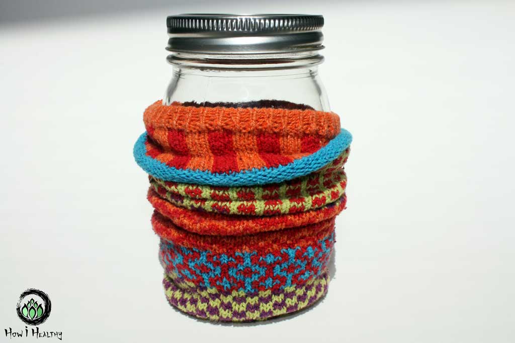 Lidded mason jar with bright sock koozie.