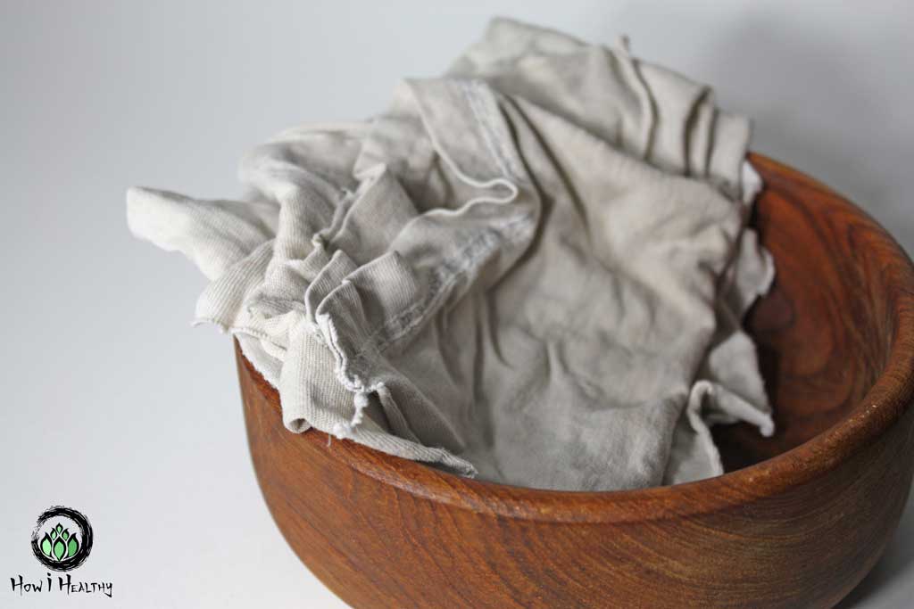 White t-shirt rag napkins with a wooden bowl.