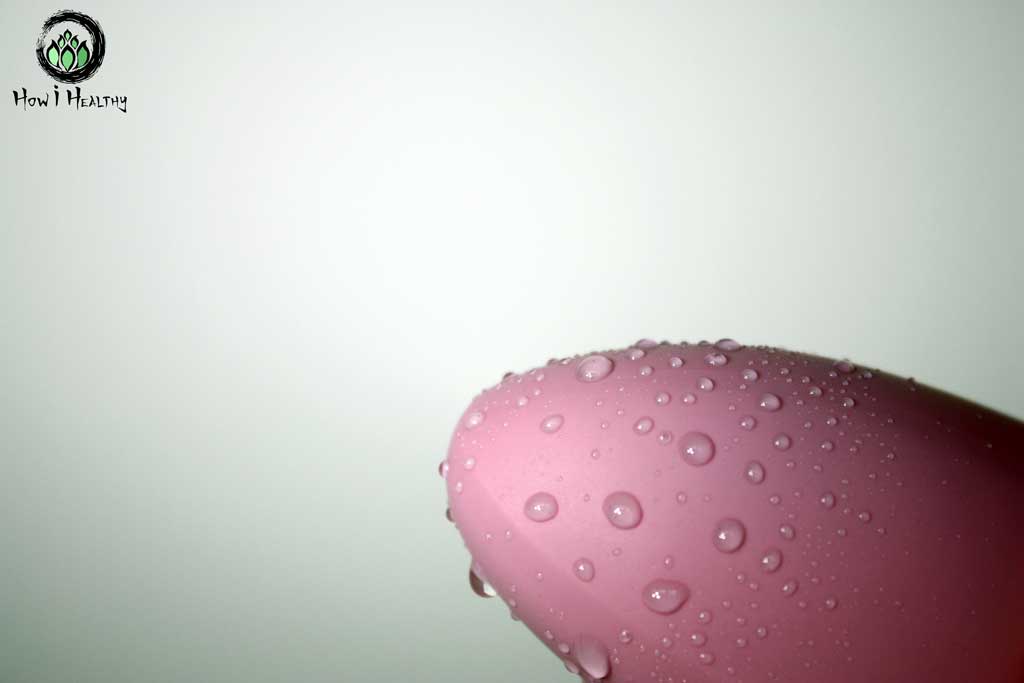 Wet pink silicone vibrator.