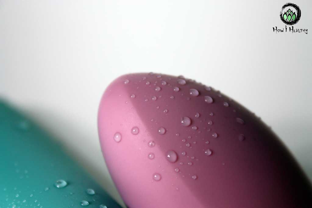 Pink silicone vibrator tip with droplets of water on it.